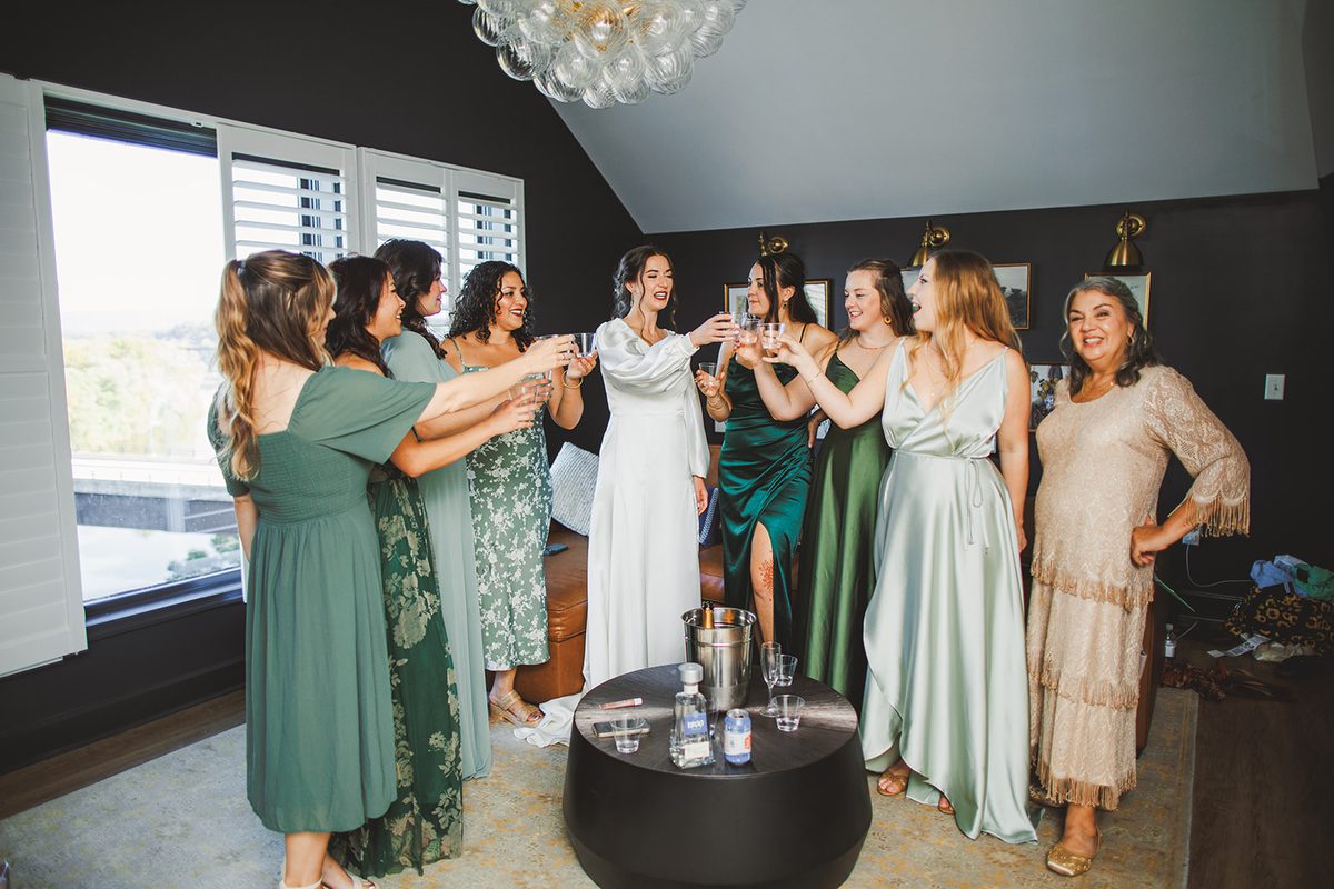 Patrick and his groomsmen raising glasses in a toast in the timber loft