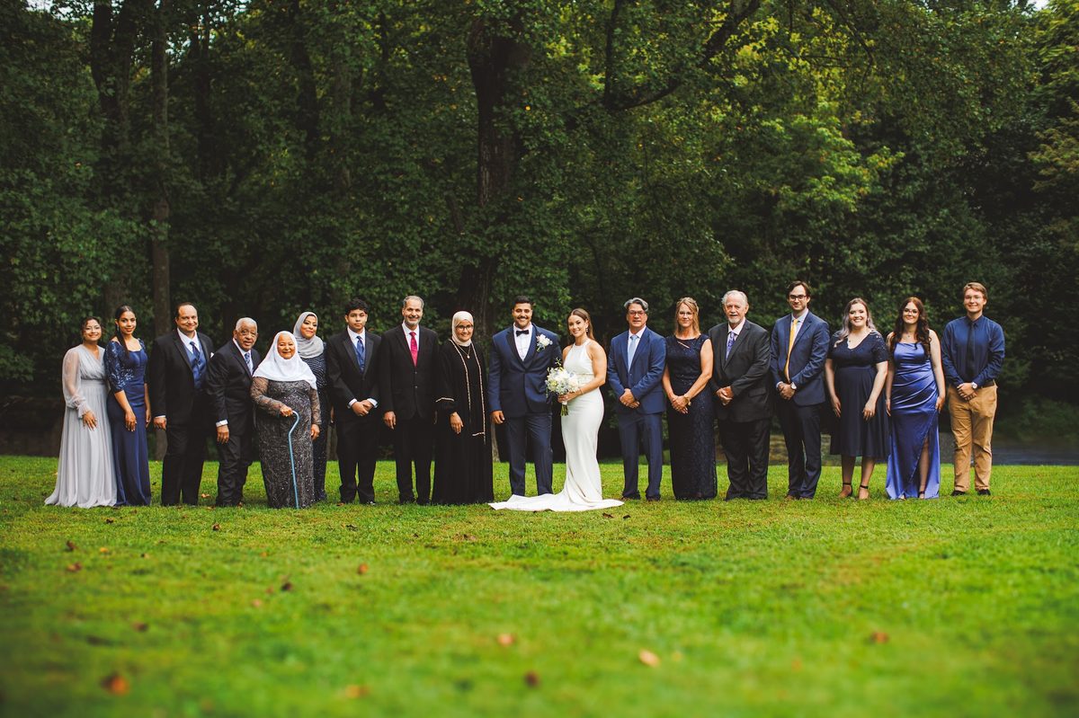 Both families lined up together on the lawn with Bailey and Youssef at the center, three generations from grandmother to youngest cousin