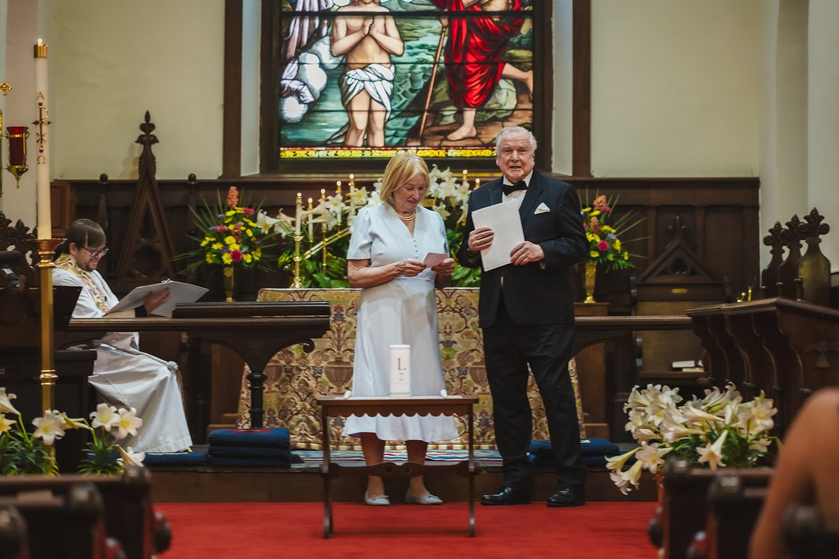 Mary and Mark facing each other at the chancel, vows in hand, the unity candle waiting on the table beside them
