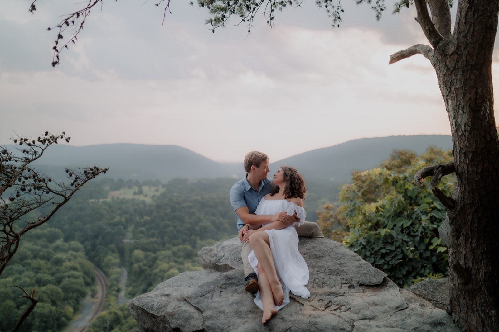 Ashley and Alan on the rock ledge at Weaverton Heights, the valley below at sunset