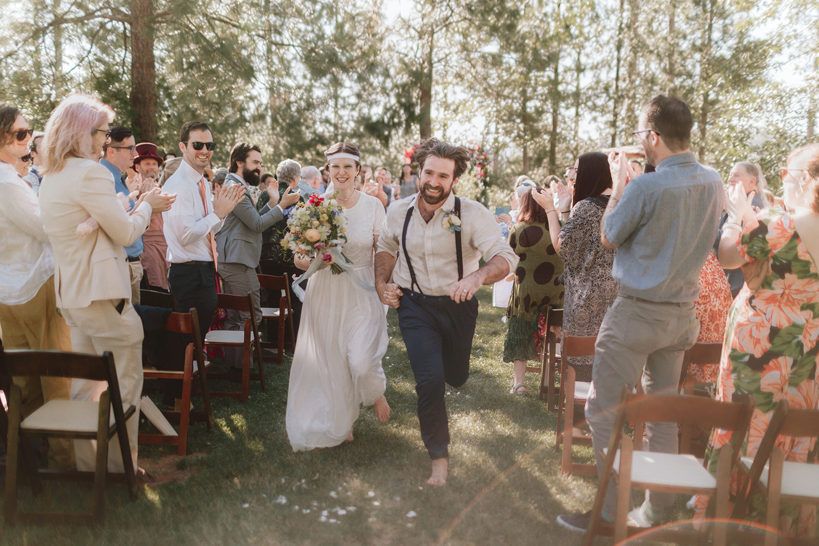 Connor and Dan running back up the aisle barefoot through applauding guests at Brice Station in Murphys, California