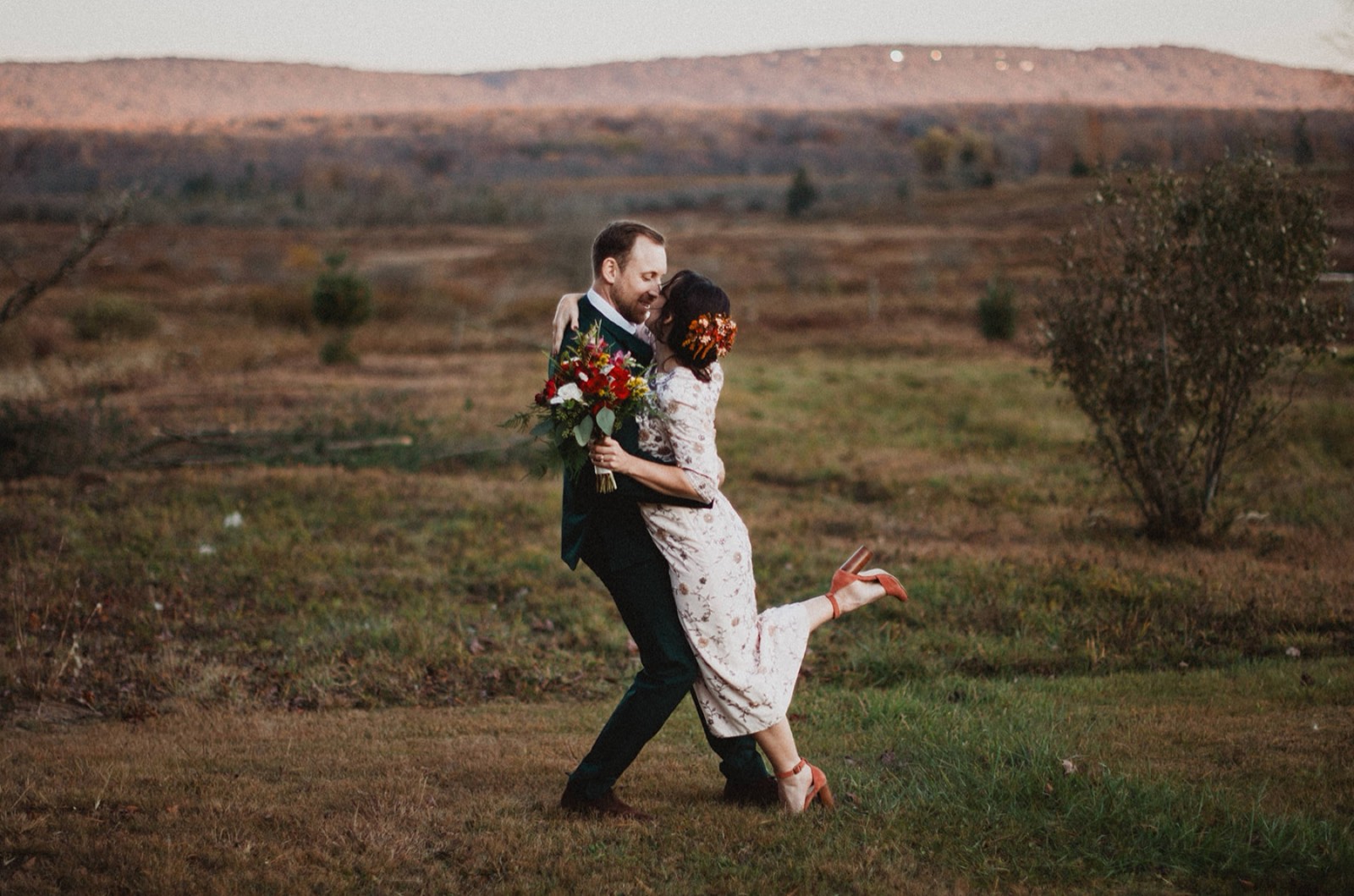 Jessica and Nathan dancing in an open autumn field at golden hour