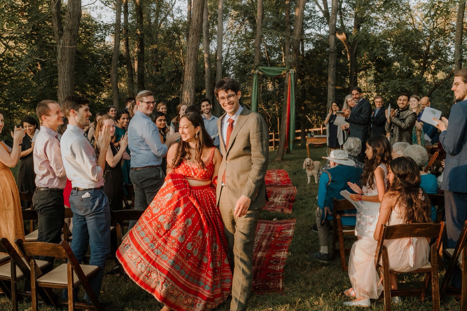 Maya and Ben's recessional through applauding guests, her red lehenga swinging