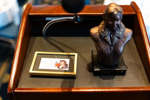 Bust, framed photo and microphone on the lectern.