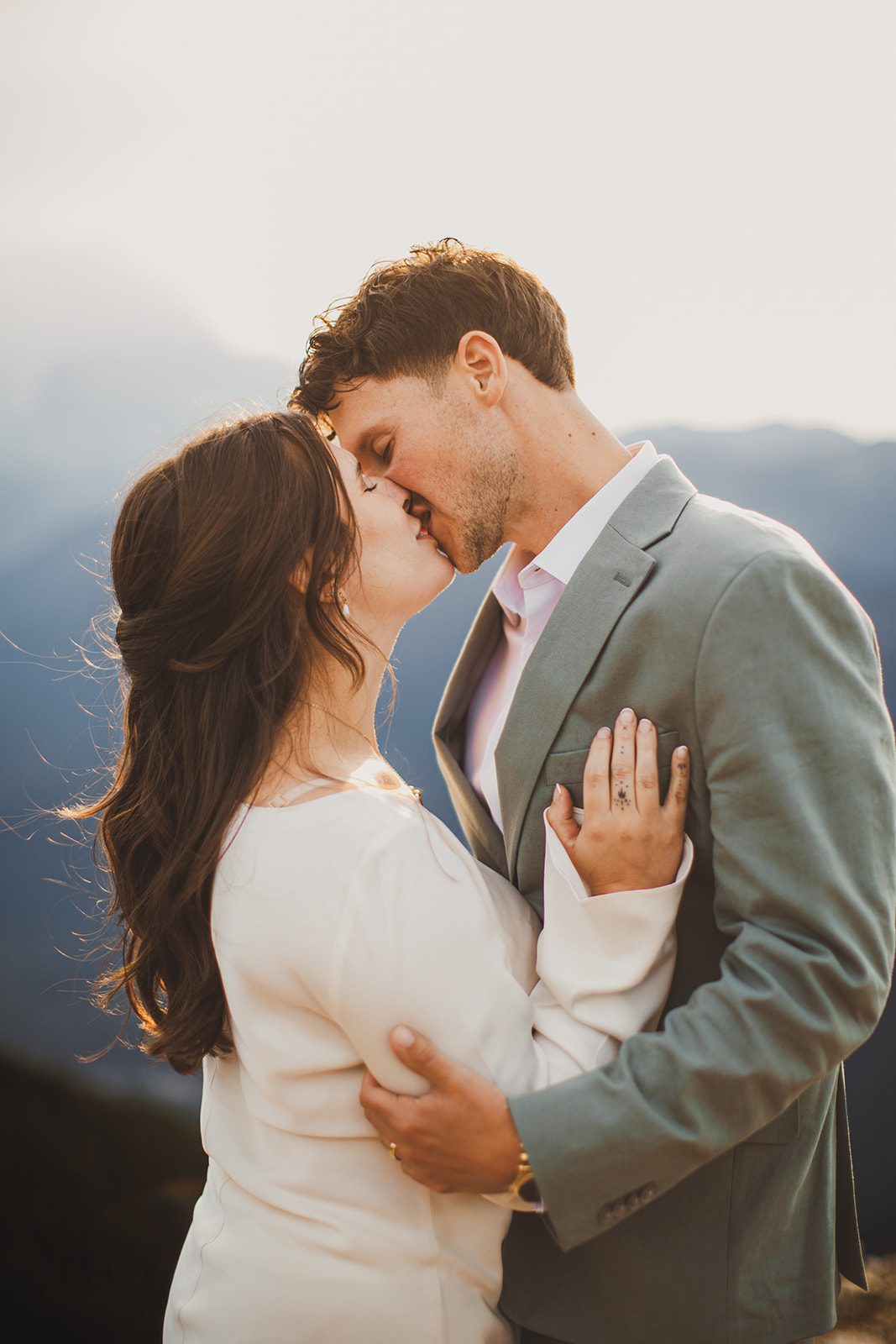 A couple resting forehead to forehead in soft mountain light, her hand on his chest