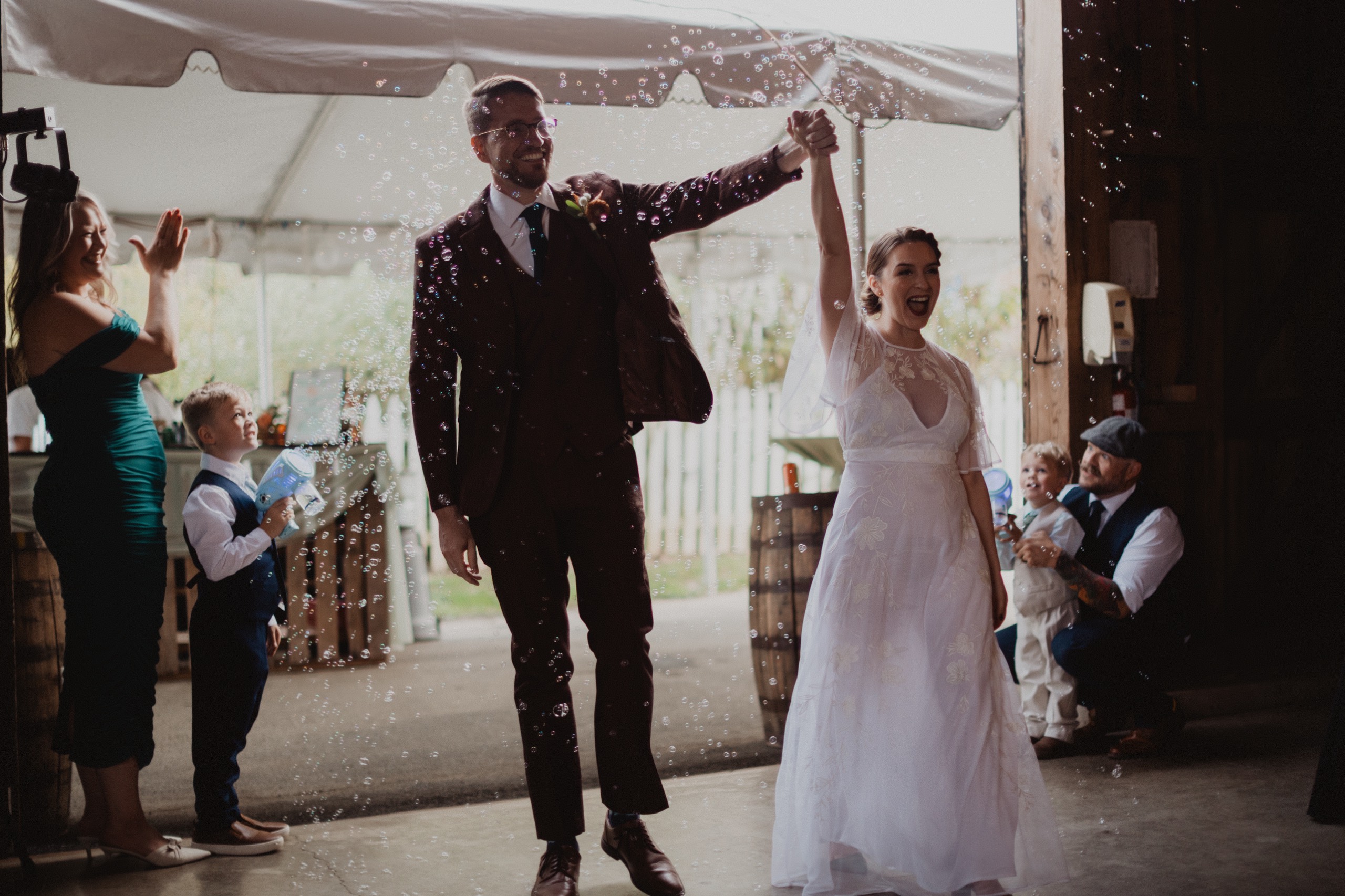 A couple raising their arms through a bubble send-off