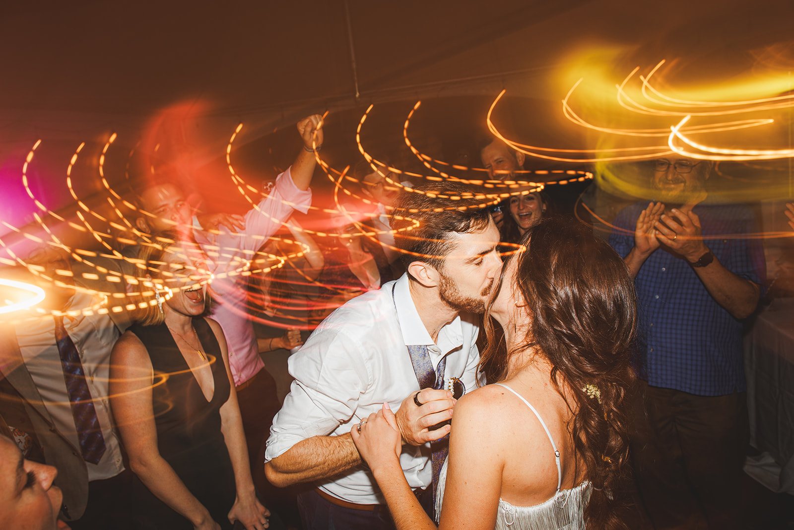 Andrea and Patrick kissing on the dance floor at the Bavarian Inn while their families clap around them