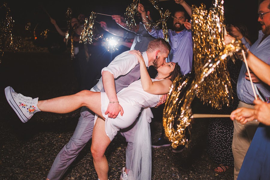 Cody dipping Amie for a kiss in the middle of their night send-off, gold streamers flaring around them