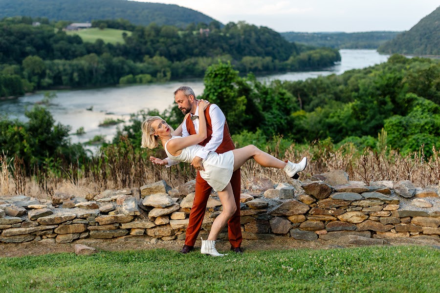 Thomas dipping Annie at the stone wall at Harpers Ferry Brewing, the wooded river valley rolling out behind them
